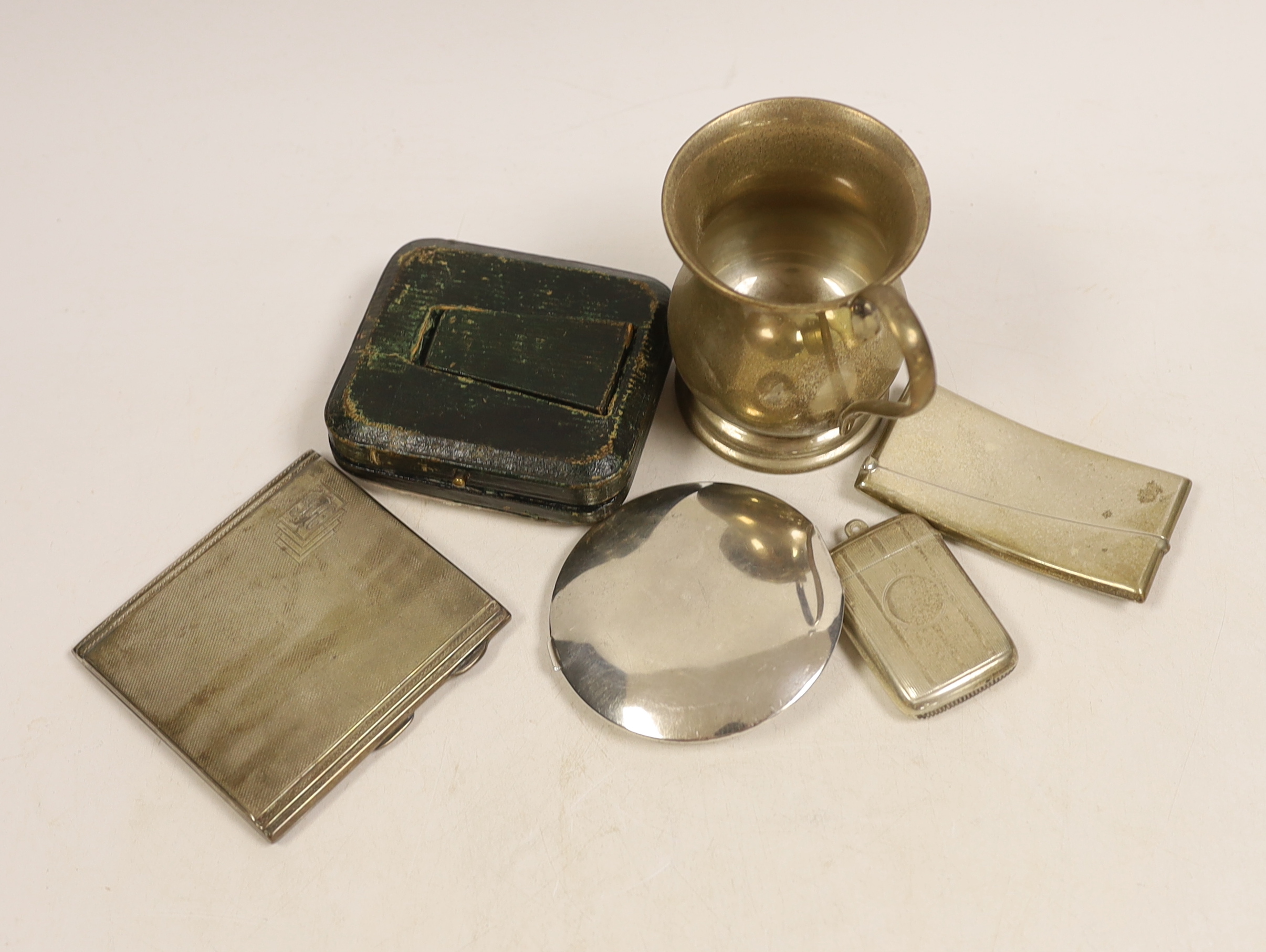 A George V silver baluster christening mug, height 9.7cm, an Edwardian silver mounted travelling watch case, containing a silver pocket watch by Peck of London, a silver card case, silver cigarette case, silver vesta cas